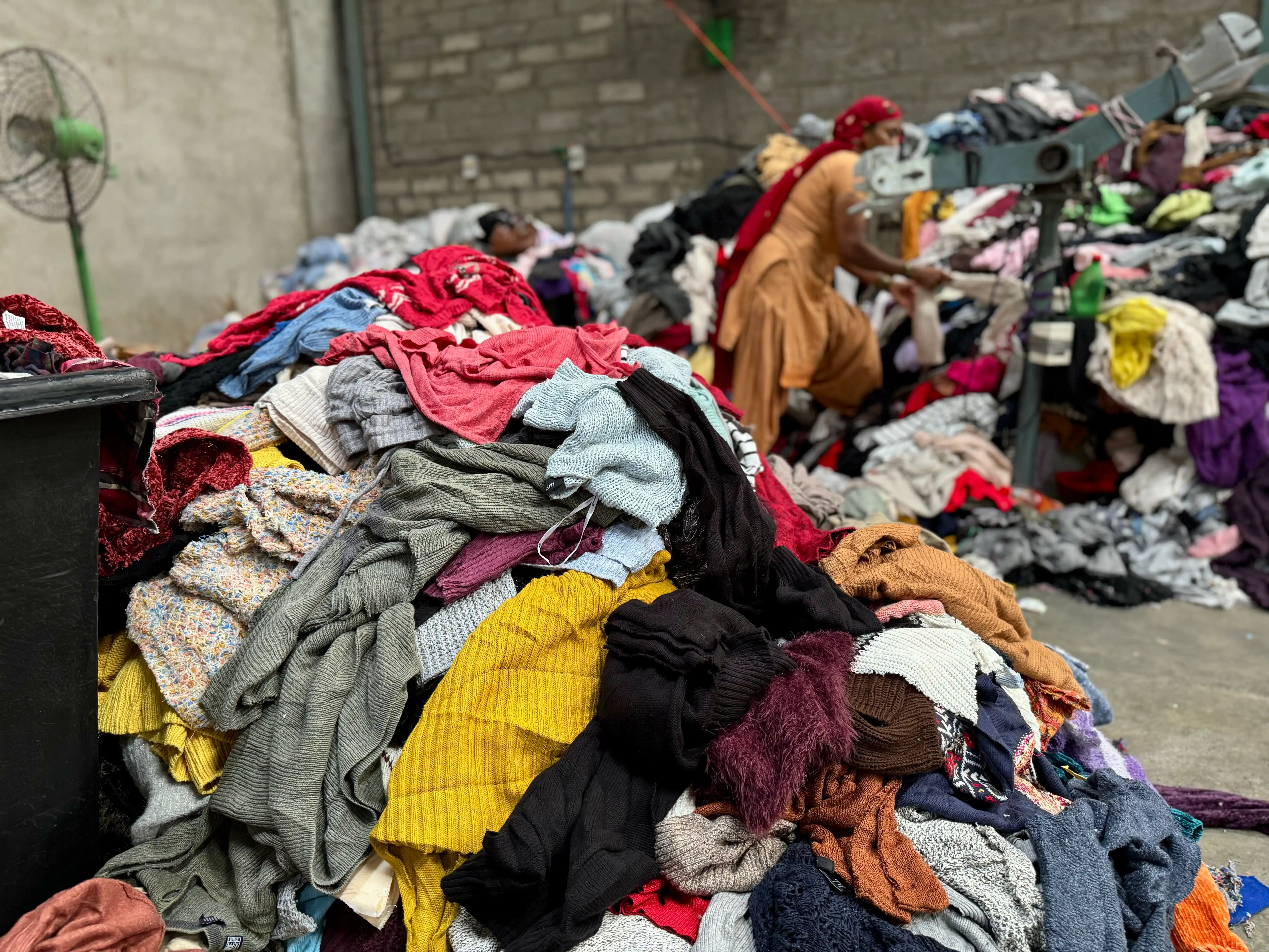 huge pile of sweaters ready to cut