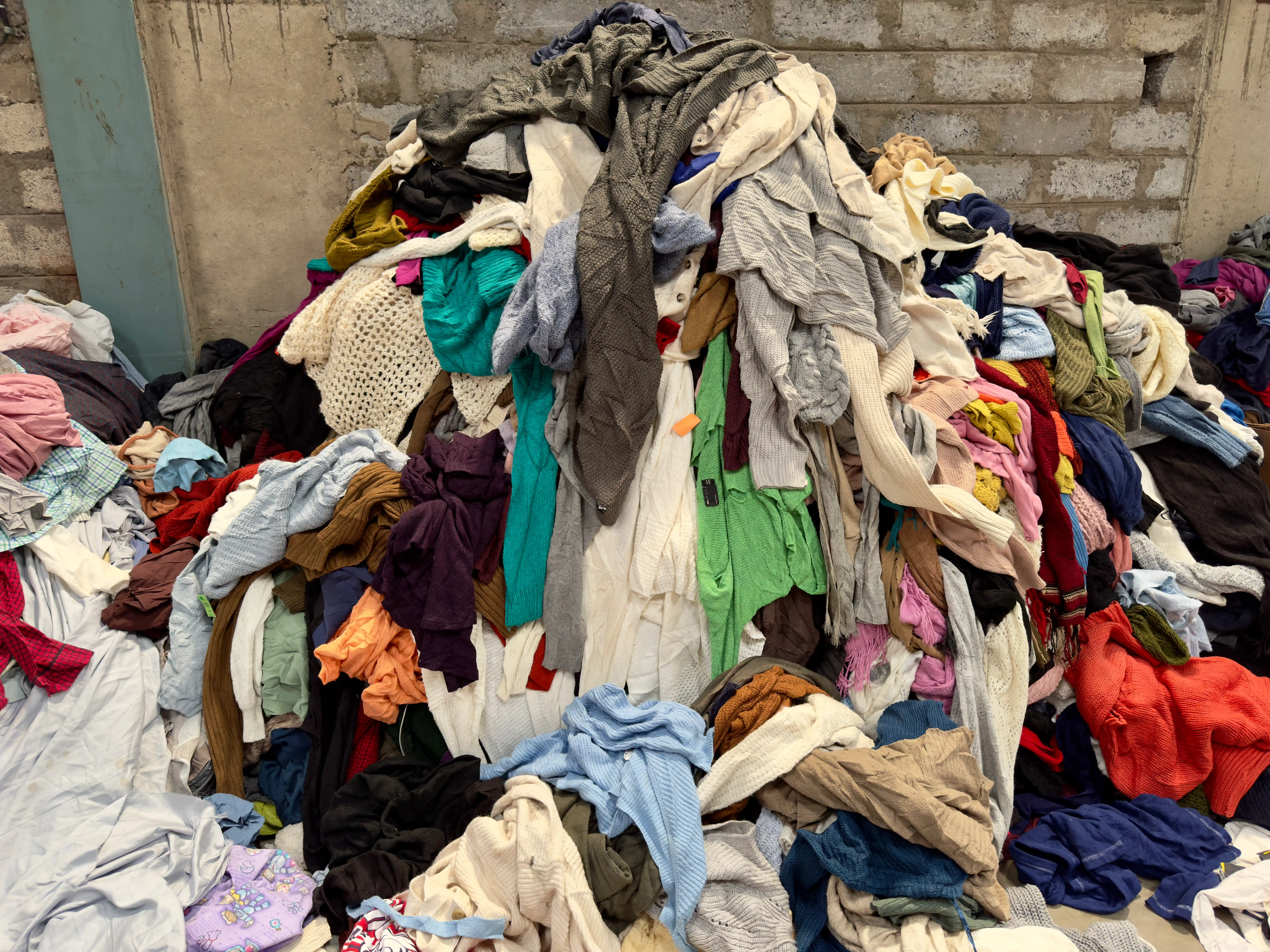 huge pile of sweaters ready to cut