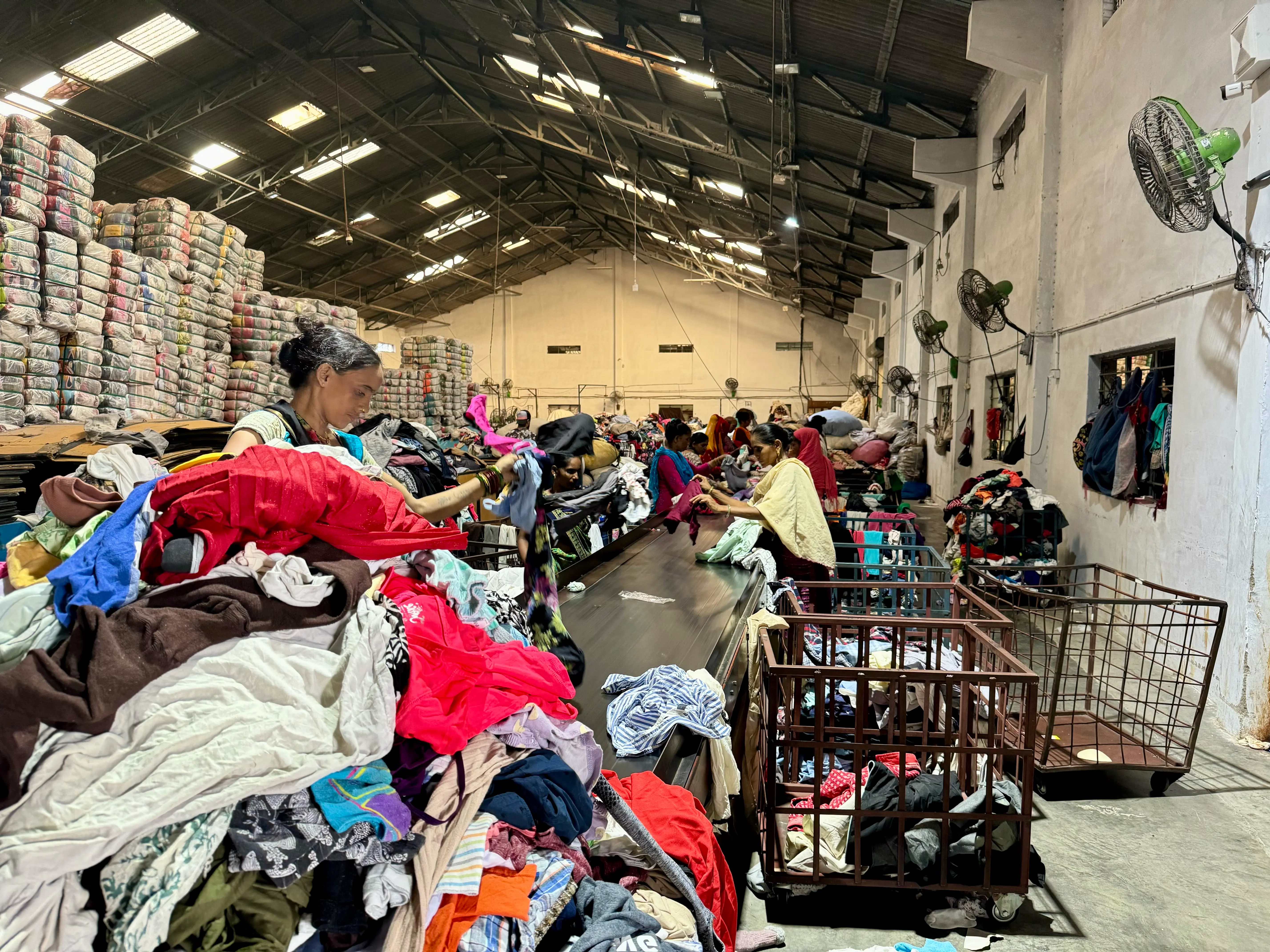 Used clothing being carefully picked from conveyor belt